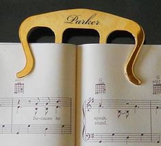 an open book with musical notes on it and a pair of scissors sticking out of the pages