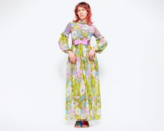 Beautiful vintage 60s Renaissance inspired bohemian maxi dress, in green with a lilac and blue floral print. It has a high collar, decorative satin buttons up the bib, a satin bow at the waist, long bishop sleeves with shirred and crocheted shoulders that resemble fish scales, and a mini skirt lining under the sheer maxi overlayer. There are hooks at the cuffs and back of collar, and a back zipper closure. Measurements and Condition: Fits like: Labeled vintage junior size 5, fits modern women's 1970s Green Floral Print Dress, 1970s Style Green Floral Print Dress, Retro Green Floral Print Maxi Dress, Retro Spring Maxi Dress For Daywear, Green Retro Maxi Dress With Floral Print, Retro Maxi Dress For Daywear, Vintage Floor-length Maxi Dress For Spring, Retro Daywear Maxi Dress, Retro Long Spring Dress