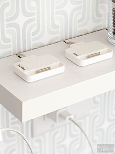 two electronic devices sitting on top of a white table