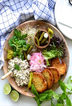 a plate filled with different types of food on top of a white table next to some green leaves