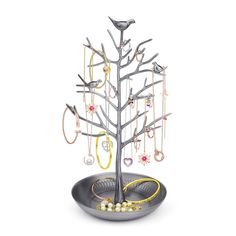 a silver tree with many different jewelry pieces hanging from it's branches and two birds perched on the branch