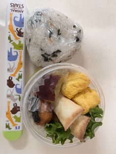 a plastic container filled with food next to a plastic toothbrush on top of a table