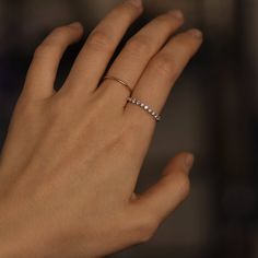 a woman's hand with a diamond ring on her left hand and the middle finger