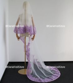 a mannequin wearing a purple wedding dress and veil