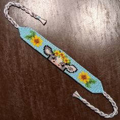 a beaded lanyard with an image of a dog and sunflowers on it