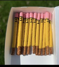 several yellow and pink candy sticks in a box