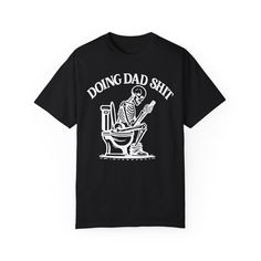 ✨💀 Introducing our "Doing Dad Shit" Skeleton T-Shirt! 💀✨ 🎉 Celebrate Father's Day with a humorous twist by gifting this custom tee featuring a skeleton on a toilet and the phrase, "Doing Dad Shit"! 🎉 💖 Crafted from 100% ring-spun cotton, this garment-dyed t-shirt offers unbeatable softness and comfort, perfect for everyday wear. 💖 😌 The soft-washed fabric adds an extra layer of coziness, making this tee an ideal choice for dads who appreciate both comfort and humor. 😌 💪 With double-needle stitching throughout, this tee is built to last, ensuring durability for all of dad's adventures. 💪 🔄 Say goodbye to bothersome side-seams – our shirt maintains its tubular shape for a sleek and flattering fit. 🔄 🎨 Show your appreciation with this fully customizable design featuring a playful Cotton T-shirt With Custom Skull Print, Unisex Casual T-shirt With Skull Print, Cotton Graphic Print T-shirt For Day Of The Dead, Day Of The Dead Skull Print T-shirt, Unisex Cotton T-shirt With Skull Print, Boxy Tee, Custom Tees, Laid Back Style, Country Chic