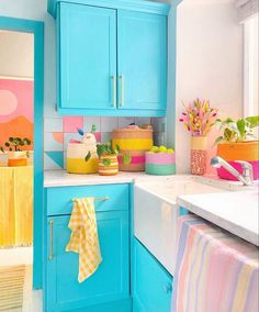 a kitchen with bright blue cabinets and colorful accessories on the counter top, along with towels