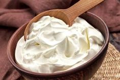 a wooden bowl filled with whipped cream on top of a table