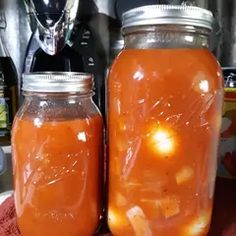 two jars filled with liquid sitting on top of a table