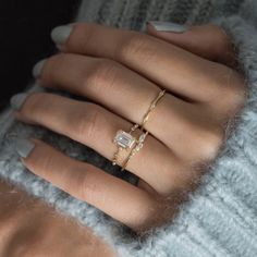 a woman's hand with two rings on it