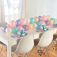 the table is set with balloons and plates