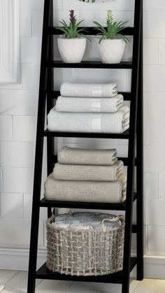 a ladder shelf with towels and baskets on it