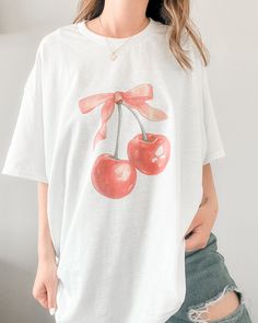 This Cherry Bow Coquette design make such an adorable, aesthetic tee or sweatshirt!  Perfect for the beach! COLORS: Tan Grey  White Pink COMFORT: Crafted from a 50% cotton and 50% polyester blend, our sweatshirt ensures maximum comfort. The sublimation printing method embeds the design directly into the fabric, making it soft to the touch and highly durable. DESIGN: The iconic design is printed in an 8.5 x 11 size on every sweatshirt, regardless of the size you choose. This ensures consistency a Trendy Crew Neck T-shirt With Cherry Print, Oversized White Print Summer Tops, Oversized White Print Top For Summer, Cute Oversized T-shirt With Screen Print, Cute Oversized T-shirt For Spring, Cute Custom Print Summer T-shirt, White Summer T-shirt With Custom Print, Cute White Top With Cherry Print, Oversized Sublimation Print Tops For Summer