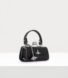 Our Doll bag features a an all-leather design, complete with this season's croc-embossed finish. The miniature silhouette draws inspiration from toy doll bags, featuring an intricately engraved kiss lock closure and our dangle orb motif, symbolising Vivienne Westwood's idea of taking tradition into the future. Vivienne Westwood Mini Bag, Vivienne Westwood Black Bag, Vivienne Westwood Bag, Vivienne Westwood Accessories, Black Vivienne Westwood, Vivienne Westwood Clutch, Vivienne Westwood Bags, Doll Bag, Image Swag