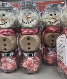 there are many snowman jars with candy in them