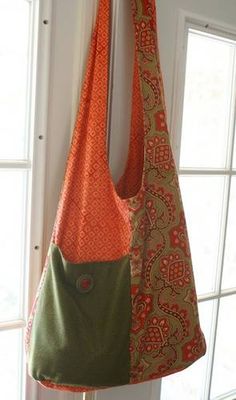 two purses hanging from the side of a door, one with an orange and green bag