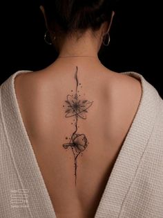 the back of a woman's neck with flowers on it