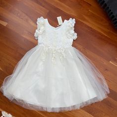 Beautiful Off-White Girls Satin And Tulle Girls Dress With Floral Details. Princess Style First Communion Dress For Spring, Spring White Princess Dress With Lace Trim, Lace Trim Princess Dress For Dress-up, White Ruffled First Communion Dress For Spring, Spring Princess Tutu Dress For Confirmation, White Spring Tutu Dress For Confirmation, Spring Confirmation Princess Dress With Ruffles, White Tutu Dress For Confirmation In Spring, White Tutu Dress For Spring Confirmation