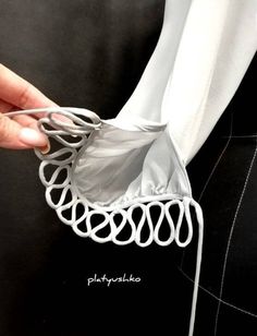 a person is holding onto a piece of clothing with metal rings attached to the back