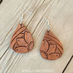 the wooden earrings are made from wood and have floral designs on them, along with silver earwires