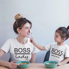 two women sitting at a table eating cereal