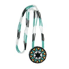 a necklace with beads on it and a black beaded disc in the center, hanging from