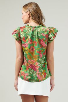 The Susy Paradise Bellissima Ruffle Sleeve Top will make you want another vacation with it’s tropical green and pink satin print. It has a highlighting silhouette followed by a split neckline and ruffle cap sleeves. The bodice maintains a classic fit that can easily be styled tucked into a pair of high waisted shorts and loafers for a classic look.- Cap sleeves- Split - Ruffle layers - Relaxed fit- Color: Green MultSize + Fit - Model is 5'8" and wearing size XS- Measurements taken from size S - Green Silk Blouse With Floral Print, Green Floral Print Summer Blouse, Summer Green Floral Print Blouse, Green Floral Silk Blouse, Green Floral Print Top For Brunch, Green Floral Print Blouse For Brunch, Chic Green Blouse For Vacation, Green Silk Vacation Tops, Green Silk Tops For Vacation