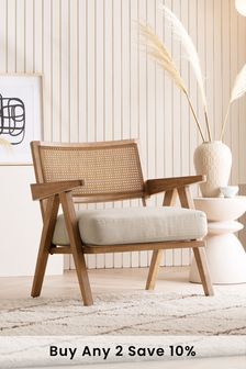 a wooden chair sitting on top of a rug next to a vase