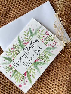 a card with the words merry and happy new year on it next to an envelope