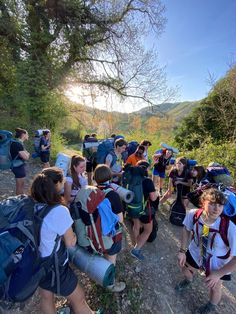 a group of people with backpacks are walking up a hill