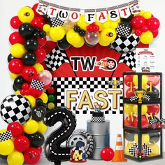 the balloon arch is decorated with black, yellow and red balloons that say two fast