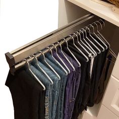 an open closet with clothes hanging on the rails and underneath it is text that reads hidden retractable hanging rods