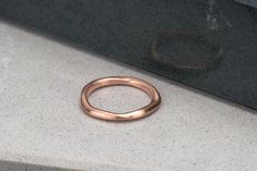 Made with SCS recycled rose gold, this organic and irregularly shaped ring gently glows from the satin finish. Looks beautiful alone, or stacked, a unique wedding band. Design Specifications: - Type: Ring - Material: SCS recycled rose gold - Width: 2.2-1.2mm - Thickness: 1.2mm - Finish: Satin Hammered Rose Gold Stackable Rings For Wedding, Wedding Stackable Hammered Rose Gold Rings, Wedding Hammered Rose Gold Stackable Rings, Rose Gold Hammered Wedding Rings, Rose Gold Square, Unique Wedding Band, Artisan Rings, Organic Rings, Hammered Rings