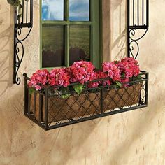 a window box filled with pink flowers next to a building