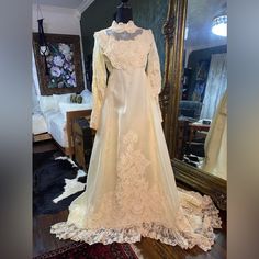 a wedding dress on display in front of a mirror