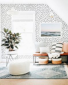 a living room with polka dot wallpaper and rugs on the floor in front of a window