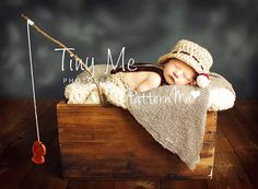 a baby is laying on top of a wooden box with a fishing hook in it's mouth