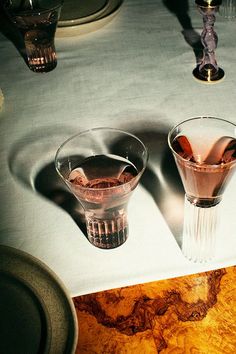 two martini glasses sitting on top of a table