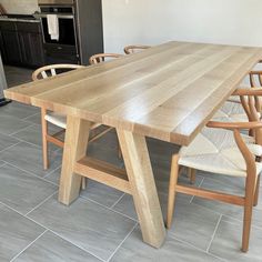 a wooden table and chairs in a room with tile flooring on the floor, next to an oven