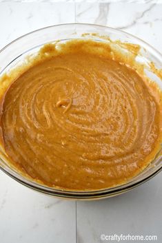 a glass bowl filled with batter on top of a white counter