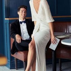 a man in a tuxedo sitting next to a woman wearing a white dress