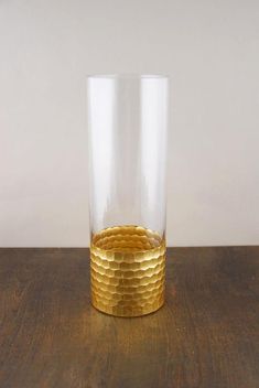 a gold colored glass sitting on top of a wooden table