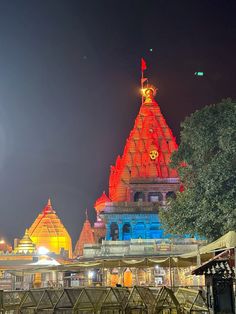 an illuminated temple at night with trees in the foreground