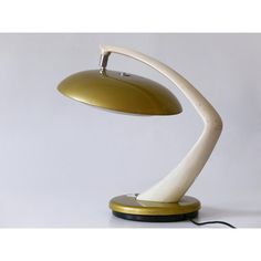 a white and gold desk lamp sitting on top of a table