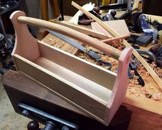 a wooden boat sitting on top of a table next to other woodworking supplies and tools