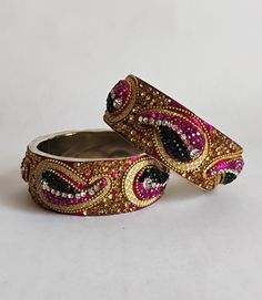 Set of 2 Bohemian Czech handmade silver tone encrusted crystal rhinestone bangle bracelet. Raised peacock or paisley design with pink, clear, gold, and emerald encrusted rhinestones, pave gold ball beads with pink and gold glitter background. Excellent vintage condition with bright stones. High quality made. Size: 1.1" x 7.25" inside (Just over 2.25" wide inside.) Thank you for visiting our shop! Please refer to photos as part of the description. Please Check out FAQs and Shop Policies and our o Gold And Emerald, Bangle Bracelet Gold, Gold Glitter Background, Glitter Background, Paisley Design, Bracelet Gold, Shop Policies, Bangle Bracelet, Gold Glitter