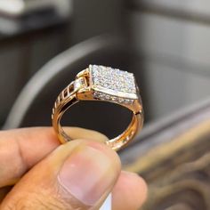 a person holding a ring in their hand with some diamonds on the top of it