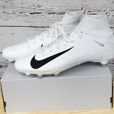 a pair of white nike soccer cleats sitting on top of a box