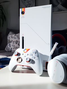 a video game controller sitting on top of a table next to headphones and a box